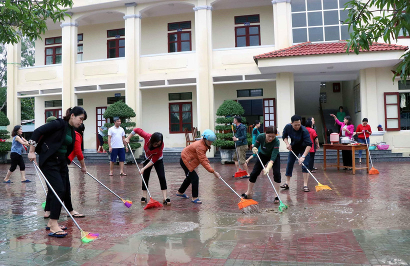 Giáo viên, phụ huynh trường THCS Thạch Linh, thành phố Hà Tĩnh vệ sinh sân trường. (Ảnh: Công Tường/TTXVN)
