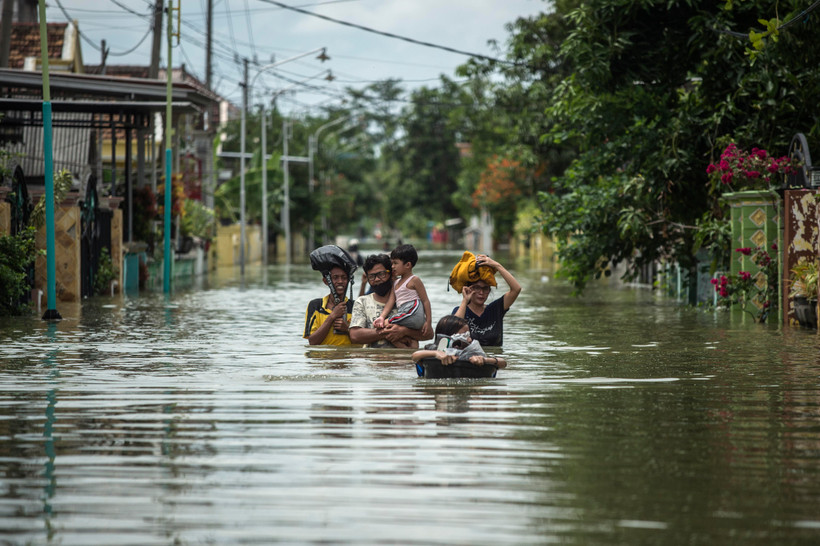 Người dân Indonesia sơ tán khỏi khu vực ngập lụt ở Gresik, Đông Java ngày 15/12/2020. (Ảnh: AFP/TTXVN)