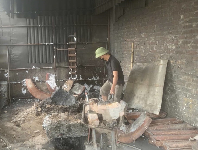 Người dân tự nguyện phá dỡ lò đốt, lò tái chế kim loại. (Ảnh: Đỗ Huyền/TTXVN)