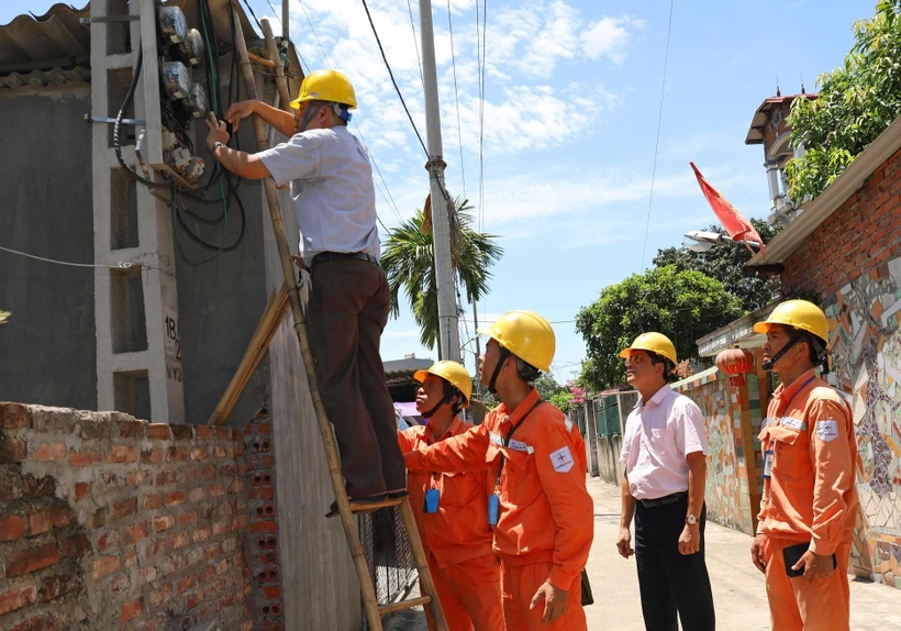 Đại diện Tổng cục Tiêu chuẩn Đo lường Chất lượng kiểm tra chì niêm phong côngtơ khách hàng sử dụng điện tại Công ty Điện lực Mê Linh, Hà Nội. (Ảnh: Ngọc Hà/TTXVN)