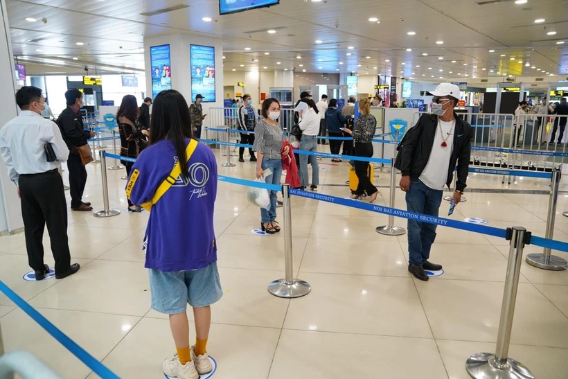 Hành khách tuân thủ khoảng cách tối thiểu 2m khi làm thủ tục tại sân bay Nội Bài sau hai ngày nới lỏng giãn cách xã hội. (Ảnh: Phan Công/Vietnam+)