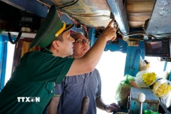 Bộ đội biên phòng Gia Lai kiểm tra thiết bị giám sát hành trình tàu cá. (Ảnh: Đình Quân/TTXVN)