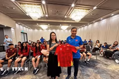 Huấn luyện viên Mai Đức Chung (phải) tặng áo thi đấu có chữ ký của các cầu thủ đội tuyển cho Tổng Lãnh sự Nguyễn Thanh Hà. (Ảnh: Thanh Tú/TTXVN)