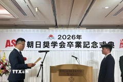 Em Lý Văn Lực (phải) nghe Đại diện Hội học bổng báo Asahi công bố quyết định khen thưởng. (Ảnh: Nguyễn Tuyến/TTXVN)