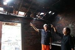 Một gia đình ở Khu phố Phước Khánh, phường Tuy Hòa phải phá ngói chạy lũ khi nước dâng cao đến 4-5 mét. (Ảnh: Tuấn Anh/TTXVN)