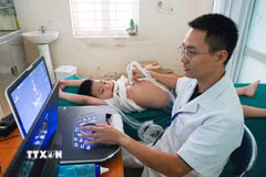 Các bác sỹ của Bệnh viện Tim Hà Nội thăm khám, siêu âm sàng lọc bệnh tim miễn phí cho nhiều trẻ em trên đia bàn tỉnh Điện Biên. (Ảnh: Phan Quân/TTXVN)