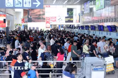 Hành khách xếp hàng đợi làm thủ tục tại sân bay Nội Bài. (Ảnh: Quốc Khánh/TTXVN)