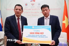 Tổng biên tập Nhà xuất bản Giáo dục Phạm Vĩnh Thái (phải) trao tượng trưng sách cho cộng đồng Việt Nam tại Liên bang Nga. (Ảnh: Tâm Hằng/TTXVN)