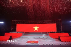 Đại biểu cùng khán giả thực hiện nghi lễ chào cờ. (Ảnh: TTXVN phát)