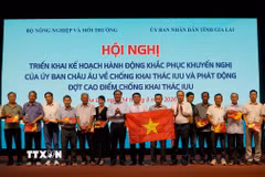 Thứ trưởng Bộ Nông nghiệp và Môi trường Võ Văn Hưng trao quà và cờ tổ quốc cho ngư dân. (Ảnh: Đình Quân/TTXVN)