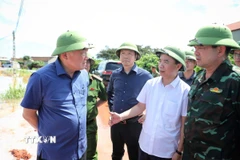 Phó Thủ tướng Thường trực Nguyễn Hòa Bình (đầu tiên, trái sang) nghe báo cáo tình hình mưa lũ. (Ảnh: Danh Lam/TTXVN)