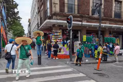 Người bán hàng chào bán mẫu áo đấu đội tuyển Mexico để thu hút khách mua. (Ảnh: Phương Lan/TTXVN)
