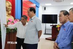 Phó Chủ tịch Quốc hội Trần Quang Phương kiểm tra bản đồ các điểm bầu cử trên địa bàn thành phố. (Ảnh: Hồng Thái/TTXVN)