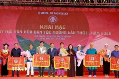 Các đại biểu tặng hoa và cờ cho 5 cộng đồng Mường đến từ Hà Nội, Sơn La, Phú Thọ, Lào Cai, Thanh Hoá tham gia Ngày hội. (Ảnh: Khánh Hoà/TTXVN)