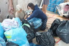 Hàng hóa được phụ nữ xã Hàm Tân, tỉnh Lâm Đồng phân loại, đóng gói trước khi gửi đồng bào miền Trung. (Ảnh: Hồng Hiếu/TTXVN)