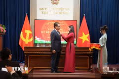 Phó Bí thư Đảng ủy tại Liên bang Nga Ngô Thị Thu Hoài gắn, trao huy hiệu 30 năm tuổi Đảng cho Đại sứ Việt Nam tại Nga Đặng Minh Khôi. (Ảnh: Trần Hải/TTXVN)