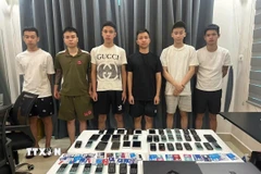 Các đối tượng và tang vật trong đường dây cho vay nặng lãi quy mô trên toàn quốc với số tiền 44 tỷ đồng bị lực lượng chức năng thành phố Đà Nẵng đã triệt phá thành công. (Ảnh: TTXVN phát)