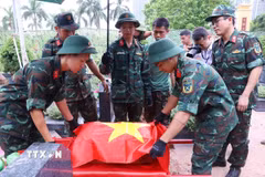 Thực hiện nghi thức phủ Quốc kỳ trang trọng, tri ân Anh hùng liệt sỹ đã hy sinh vì độc lập, tự do của Tổ quốc tại Nghĩa trang Mai Dịch (phường Phú Diễn). (Ảnh: Văn Điệp/TTXVN)