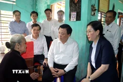 Đồng chí Nguyễn Xuân Thắng đến thăm, tặng quà vợ liệt sĩ Đoàn Bưởi ở thôn Vạn An 3, xã Tư Nghĩa. (Ảnh: Cao Nguyên/TTXVN)