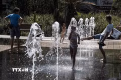 Người dân tránh nóng bên đài phun nước ở Nice, Pháp. (Ảnh: THX/TTXVN)