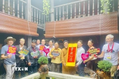 Các phóng viên quốc tế chụp ảnh lưu niệm tại làng nghề Bát Tràng (Hà Nội). (Ảnh: Tuyết Mai/TTXVN)