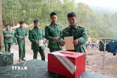 Các chiến sỹ Tiểu đoàn 1, Lữ đoàn 543, Quân khu 2 tiến hành bỏ phiếu vào thùng phiếu phụ của Tổ bầu cử số 1, xã Sín Thầu. (Ảnh: Trung Kiên/TTXVN)