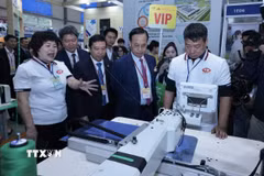 Các đại biểu tham quan gian trưng bày tại triển lãm. (Ảnh: Trần Việt/TTXVN)