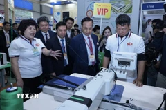 Các đại biểu tham quan gian trưng bày tại triển lãm. (Ảnh: Trần Việt/TTXVN)