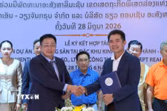 Ông Lê Huy Hoàng, Tổng Giám đốc Công ty Trách nhiệm hữu hạn KN Vientiane Group và ông Bouavieng Champaphan, Giám đốc Công ty Trách nhiệm hữu hạn Bất động sản Real Concept trao đổi văn kiện hợp tác sau lễ ký. (Ảnh: Văn Phiên/TTXVN)
