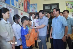 Chủ tịch Ủy ban Nhân dân tỉnh Bắc Ninh Vương Quốc Tuấn (thứ 2, phải sang) động viên, tặng quà trẻ em xã Tam Giang. (Ảnh: Thái Hùng/TTXVN)