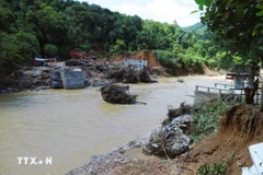 Nước lũ cuốn trôi nhịp cầu Xốp Chạng trên Quốc lộ 48C, làm biến dạng hoàn toàn lòng suối khu vực hai bên cầu. (Ảnh: Xuân Tiến/TTXVN)