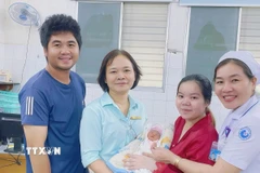 Bé sơ sinh được xuất viện trong niềm vui của gia đình và đội ngũ y bác sỹ. (Ảnh: TTXVN phát)