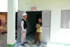 Chính quyền xã Măng Ri thăm hỏi gia đình anh A Hon (sinh năm 1990, trú tại thôn Lộc Bông) được nhận căn nhà mới trong Chiến dịch Quang Trung. (Ảnh: Dư Toán/TTXVN)