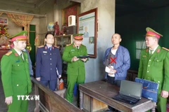 Cơ quan Cảnh sát điều tra Công an tỉnh thi hành lệnh bắt bị can Lê Minh Vũ. (Ảnh: TTXVN phát)