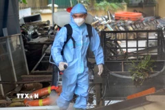 Nhân viên y tế xịt khử khuẩn tại Công an phường Hương An, thành phố Huế. (Ảnh: Văn Dũng/TTXVN)