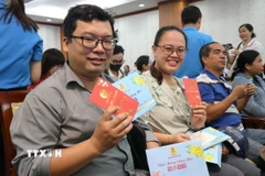 Công nhân lao động vui mừng nhận quà Tết. (Ảnh: Thanh Vũ/TTXVN)