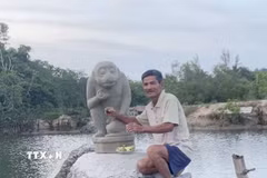 Ông Dương Đình Lục và tượng Khỉ Hanuman do ông trục vớt được. (Ảnh: TTXVN phát)
