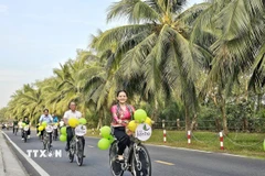 Du khách trải nghiệm "du lịch xanh" dưới tán dừa trên các cung đường phường An Hội, tỉnh Vĩnh Long. (Ảnh: Chương Đài/TTXVN)