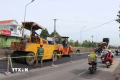 Thi công hoàn trả mặt bằng Quốc lộ 1 đoạn qua Khu công nghiệp VSIP. (Ảnh: Phạm Cường/TTXVN)