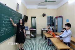 Cô và trò Trường PTCS Dân lập dạy trẻ câm điếc Hà Nội. (Ảnh: Hoàng Hiếu/TTXVN)