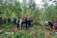 Cơ quan chức năng cứu hộ ông Phan Văn Hóa đang nằm dưới giếng sâu. (Ảnh: TTXVN phát)