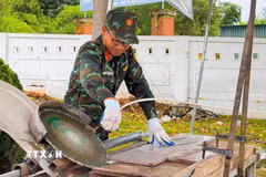 Trung tá Nguyễn Văn Ngọc với chiếc máy mòi đá. (Ảnh: TTXVN phát)