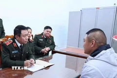 Lực lượng công an làm việc với đối tượng Fan Mingzhen sau khi bị bắt giữ. (Ảnh: TTXVN phát)