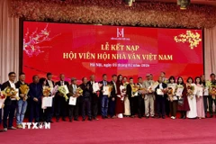 Đại diện Ban chấp hành Hội Nhà văn Việt Nam trao quyết định kết nạp hội viên mới. (Ảnh: Phương Lan/TTXVN)