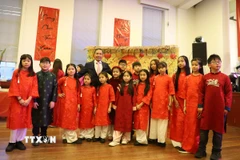 Đại sứ Đỗ Minh Hùng chụp ảnh lưu niệm với các cháu thiếu nhi của Cộng đồng người Việt Nam tại Anh. (Ảnh: Hữu Tiến/TTXVN)