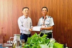 Ông Nguyễn Đức Vũ Trưởng Ban Quản lý đã trao giấy khen và khen thưởng đột xuất cho anh Phan Thanh Trinh (phải). (Ảnh: TTXVN phát).