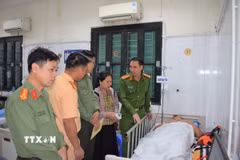Lãnh đạo Công an tỉnh Hưng Yên thăm hỏi, động viên Đại úy Vũ Trường Giang đang điều trị tại Bệnh viện Việt Đức. (Ảnh: TTXVN phát)