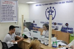 Người dân được cán bộ, công chức hỗ trợ giải quyết hồ sơ tại Điểm phục vụ Hành chính công phường Hai Bà Trưng (Hà Nội). (Ảnh: Vũ Quang/TTXVN).