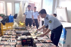 Lực lượng chức năng kiểm tra số hàng không rõ nguồn gốc. (Ảnh: TTXVN phát)