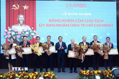 Chủ tịch Ủy ban Nhân dân Thành phố Hồ Chí Minh Nguyễn Văn Được trao tặng Bằng khen cho các tập thể, cá nhân xuất sắc. (Ảnh: Tiến Lực/TTXVN)